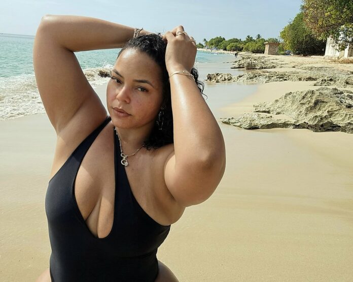 Brittany Dawson, founder of Curve Swim, on a St. Croix beach in a black swimsuit
